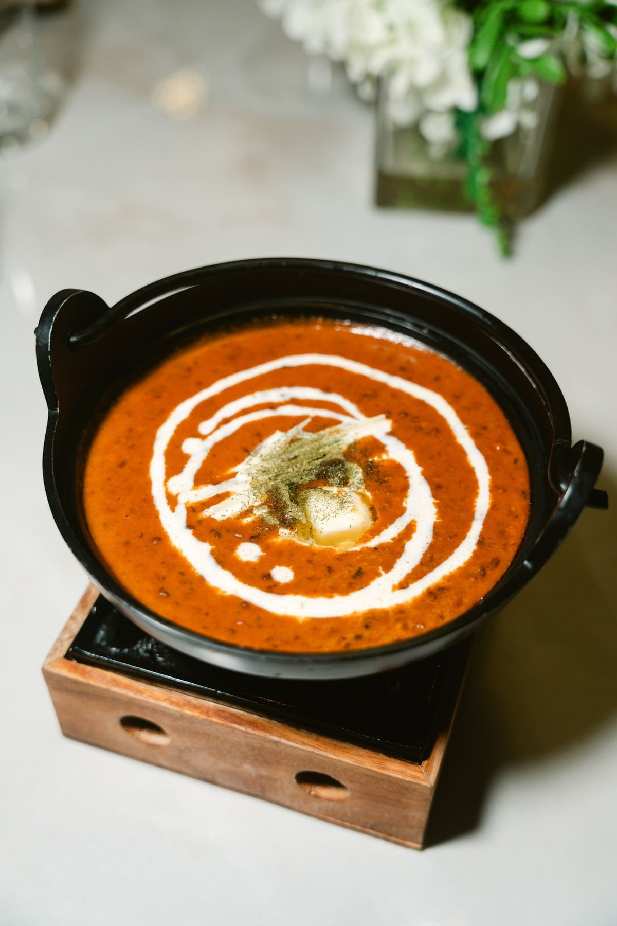 Dal makhani finished with a swirl of cream and butter in a black handi